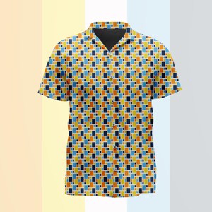 Puede incluir: Una camisa de manga corta con botones que presenta un patrón geométrico repetitivo de pequeños rectángulos en tonos naranja, amarillo, azul claro y azul marino oscuro. La camisa tiene un cuello clásico, una tapeta de botones y un dobladillo recto.