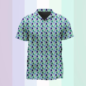 Puede incluir: Una camisa de manga corta con botones y un patrón geométrico repetitivo de pequeños rectángulos en tonos azul oscuro, azul claro y verde menta. La camisa cuenta con un cuello clásico, una tapeta de botones frontal y un dobladillo recto.