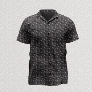 May include: A short-sleeved button-down shirt in a dark charcoal grey colour featuring an all-over repeating pattern of small white flowers and thin, winding light pink stems. The shirt has a classic collar and a front button placket.