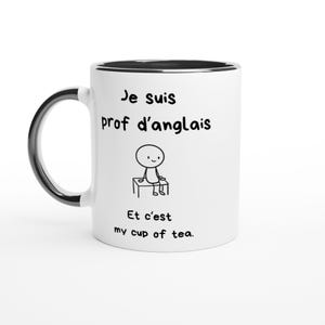 Puede incluir: Una taza de cerámica blanca con asa e interior negros. El frente presenta un dibujo lineal negro de una figura de palo sentada en un banco, con el texto "Je suis prof d'anglais" arriba y "Et c'est my cup of tea." impreso debajo de la figura.