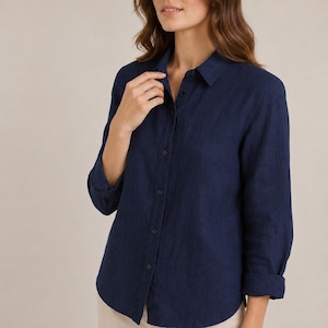 May include: A dark navy blue long-sleeved button-down shirt featuring a classic collar, a front button placket, and sleeves that are rolled up to the elbows. The shirt has a textured appearance and a straight hemline, providing a clean look.