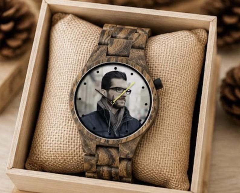 May include: A wooden wristwatch with a link band and a round face featuring a photographic portrait of a person wearing glasses and a dark jacket. The watch has black hour markers, black hour and minute hands, and a yellow second hand.