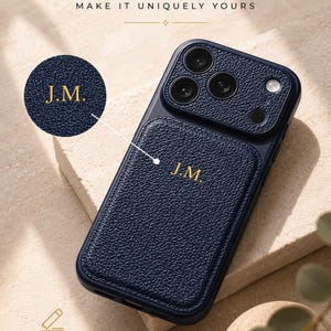 Peut inclure: Une coque de téléphone bleu marine texturée avec un porte-cartes magnétique arborant les initiales J.M. dorées. La coque présente une découpe pour l'appareil photo et un encart circulaire montrant les initiales. Texte : Personalizable Make it uniquely yours.