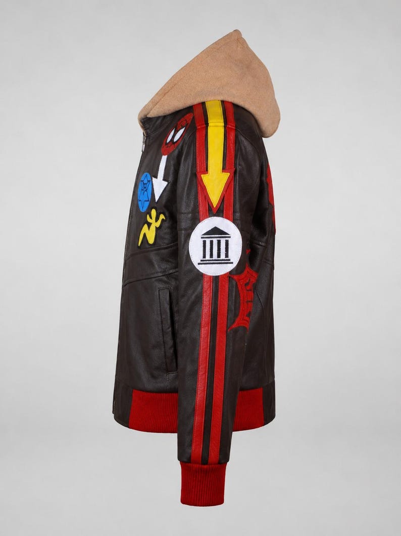 May include: A dark brown leather jacket featuring a tan hood, red ribbed cuffs, and a red hem. The sleeve displays a yellow arrow, a white circular patch with a black temple icon, and various colorful embroidered patches including a red spider mask.