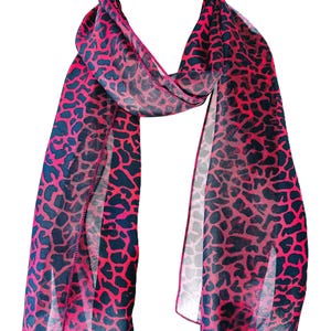 May include: A lightweight, semi-sheer scarf featuring a vibrant hot pink and black animal print pattern. The fabric has a delicate, flowing texture with finished edges, draped in a loop to display the repeating dark spots against the bright background.