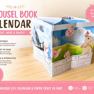 May include: A carousel book calendar paper craft featuring illustrated scenes of a rabbit, butterflies, and a winter house. The structure is made of folded paper panels with printed monthly calendar grids. Text on the image includes CAROUSEL BOOK CALENDAR, PRINT, MAKE & ENJOY, START SUN & MON, PRINTABLE, EASY TO MAKE, FUN & INTERACTIVE, INSTANT DOWNLOAD, and A UNIQUE DIY CALENDAR & PAPER CRAFT IN ONE.