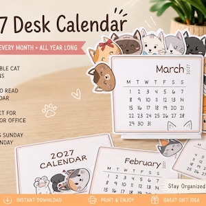 Può includere: Un calendario da scrivania 2027 con illustrazioni di gatti. Il calendario mostra il mese di marzo con una griglia di date, circondato da vari volti di gatti disegnati. Sono visibili sotto le pagine del calendario di gennaio e febbraio.