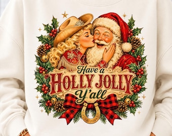 May include: A cream-colored sweatshirt featuring a graphic of a blonde person in a cowboy hat kissing Santa Claus. The design includes holly, pinecones, a red and black buffalo plaid bow, a gold horseshoe, and the text Have a HOLLY JOLLY Y'ALL.
