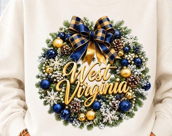 May include: A cream-colored sweatshirt featuring a graphic of a Christmas wreath decorated with blue and gold ornaments, pinecones, snowflakes, and a large blue and gold plaid bow. The text West Virginia is written in gold script.