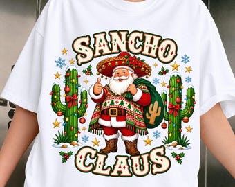 May include: A white t-shirt featuring a graphic of Santa Claus wearing a sombrero and cowboy boots, giving a thumbs up. He is flanked by two cacti decorated with Christmas lights and ornaments. The text SANCHO CLAUS is printed in large, stylized letters above and below the illustration.