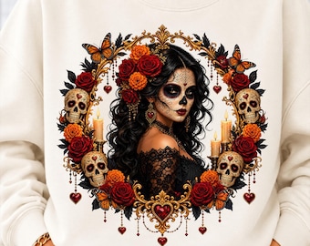 May include: A cream-colored sweatshirt featuring a graphic print of a person with sugar skull makeup, surrounded by a circular frame of red roses, orange marigolds, skulls, butterflies, and lit candles with hanging heart-shaped charms.