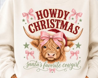 May include: A cream-colored sweatshirt featuring a graphic of a Highland cow wearing a Santa hat and a pink bow. The text reads HOWDY CHRISTMAS and santa's favorite cowgirl, surrounded by pink bows and green stars on the front of the garment.