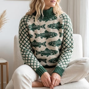 Könnte beinhalten: Ein langärmeliger Rollkragenpullover mit cremefarbener Basis, verziert mit einem sich wiederholenden dunkelgrünen Fischmuster auf dem Rumpf und einem dunkelgrünen Rautenmuster auf den Ärmeln. Das Kleidungsstück hat gerippte Bündchen und einen Rollkragen.
