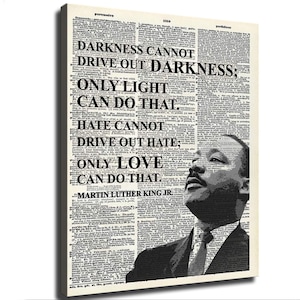 Könnte beinhalten: Ein rechteckiger Leinwanddruck mit einem schwarz-weißen Porträt von Martin Luther King Jr., das über eine Wörterbuchseite gelegt ist. Der Text lautet: Darkness cannot drive out darkness; only light can do that. Hate cannot drive out hate; only love can do that. Martin Luther King Jr.