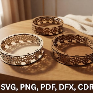 May include: Three circular wooden trays featuring laser-cut floral patterns along the side walls. Each tray has a flat base and a decorative border composed of repeating flower shapes. The text SVG, PNG, PDF, DFX, CDR is displayed at the bottom.