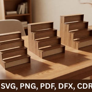 May include: Three tiered wooden display stands with a light brown wood grain finish. Each stand features four levels for organizing items. The text SVG, PNG, PDF, DFX, CDR is displayed at the bottom of the image in white capital letters.