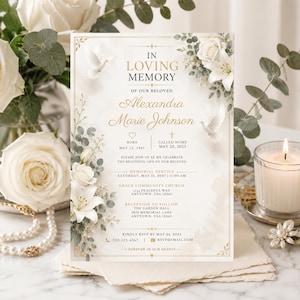 Può includere: Un biglietto d'invito per un servizio commemorativo con il testo In Loving Memory of our beloved Alexandra Marie Johnson, incluse date, luogo e contatti. Il design presenta rose bianche, gigli e colombe bianche in volo.