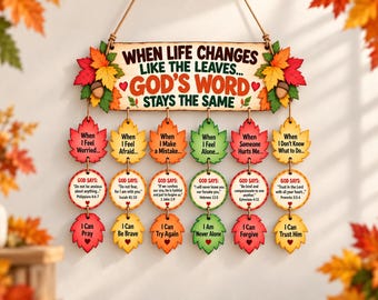 May include: A wooden wall hanging featuring the text "WHEN LIFE CHANGES LIKE THE LEAVES... GOD'S WORD STAYS THE SAME" decorated with autumn leaves and acorns. Six vertical strands of wooden leaf and circle shapes display inspirational messages.