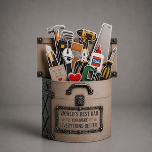 May include: A cylindrical tan storage container with a metal handle and a plaque reading WORLD'S BEST DAD YOU MAKE EVERYTHING BETTER. It is filled with cutouts of tools including a hammer, drill, saw, glue, and a card saying Best Dad in the World.