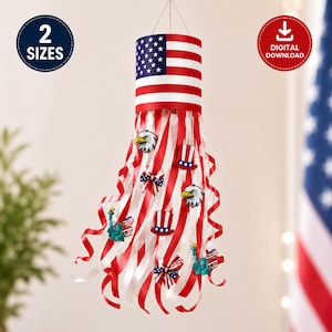 May include: A hanging windsock decoration featuring a cylindrical top with the American flag pattern and long, flowing red and white ribbons. The ribbons are adorned with small graphic icons of bald eagles, top hats, and the Statue of Liberty.