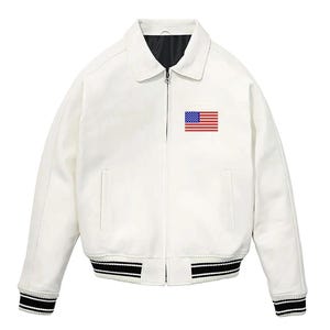 May include: A white jacket with a classic collar and a full-length front zipper. The chest features a small embroidered United States flag patch. The cuffs and hem are finished with black and white striped ribbed trim, and the interior is black.