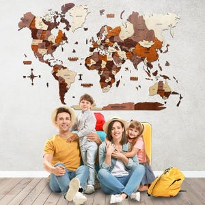 May include: A large, multi-layered wooden world map wall art piece featuring various shades of brown and natural wood tones. The map includes laser-cut continents, country names, ocean labels, a compass rose, and a separate Antarctica panel.