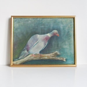 May include: A framed painting of a pigeon perched on a branch. The bird has gray and pink feathers, a red beak, and is set against a blue and green background. The frame is gold.