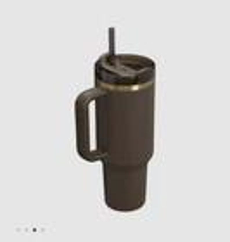 May include: A dark brown insulated tumbler with a matching handle, a black lid, and a black straw. The cylindrical container features a metallic gold-toned ring accent just below the lid, providing a contrast to the matte dark brown finish.