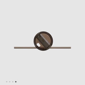 May include: A dark brown, translucent circular lid with a rotating closure mechanism and a matching dark brown straw extending horizontally through the center. The lid features a small, embossed logo detail on the top surface of the closure.