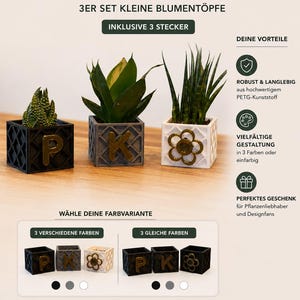 Könnte beinhalten: Ein Set aus drei quadratischen Pflanzgefäßen in Schwarz, Grau und Weiß, jeweils mit Gittermuster und einem individuellen Emblem auf der Vorderseite. Der schwarze Topf zeigt den Buchstaben P, der graue den Buchstaben K und der weiße eine Blume.