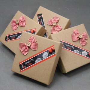 May include: Five brown cardboard boxes with red and white gingham bows and a label that reads "Jewelry By Vita".