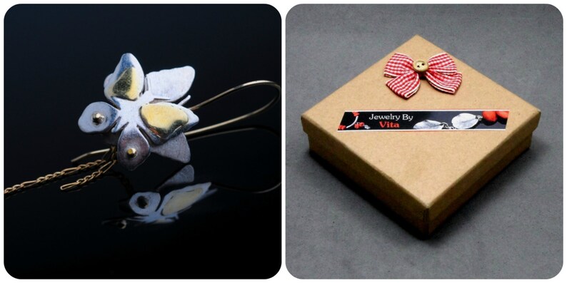 May include: Silver and gold butterfly earrings with a delicate chain detail. The earrings are packaged in a brown box with a red and white gingham bow and a "Jewelry By Vita" label.