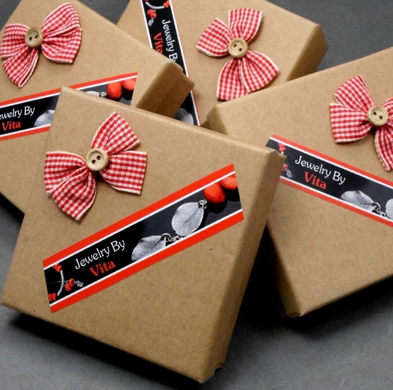 May include: Multiple brown cardboard boxes with red and white gingham bows and a black and white label that reads "Jewelry By Vita".