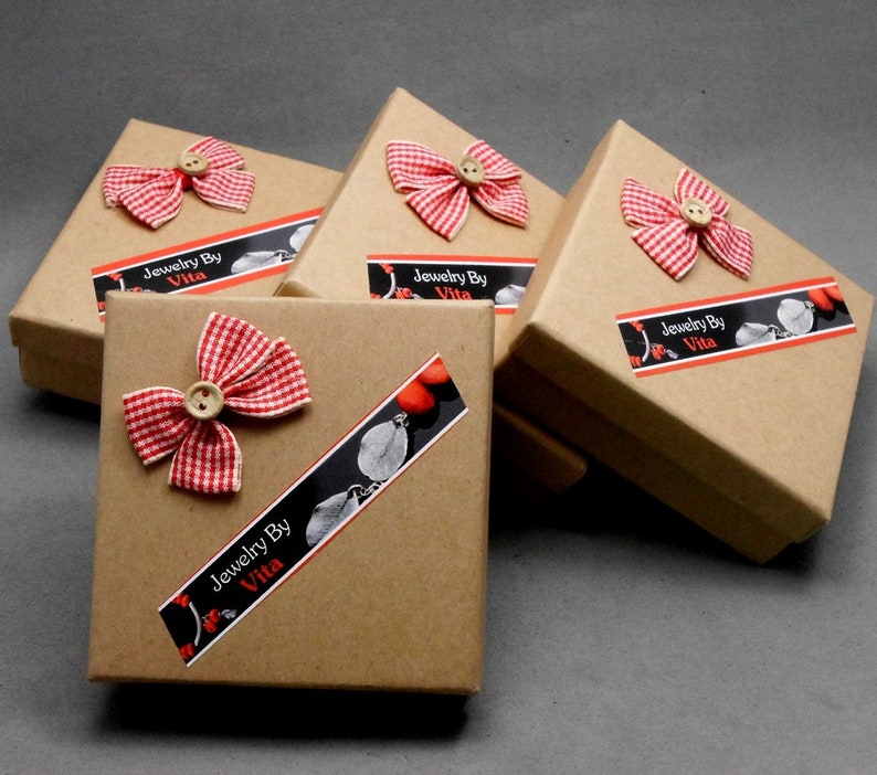 May include: Four small brown cardboard boxes with red and white gingham bows and a label that reads "Jewelry By Vita".