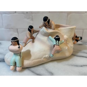 Bloempot in de vorm van een mocassinlaars uit het zuidwesten van de VS, met handgeschilderde vertellersfiguren.