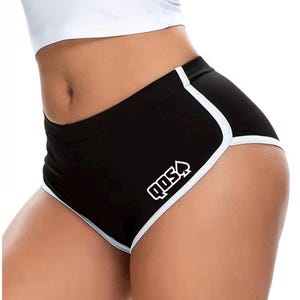 Può includere: Pantaloncini sportivi neri con bordo bianco lungo le aperture delle gambe e sui lati. La parte anteriore dei pantaloncini mostra il testo bianco QDS seguito da un simbolo di picche bianco. I pantaloncini hanno una vestibilità a vita alta.