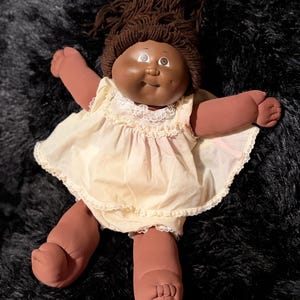 Bambola Cabbage Patch Kids Black Girl Vintage 1983 - Capelli castani con chignon e coda di cavallo, occhi marroni, vestito a grembiule in pizzo color avorio e crema Coleco CPK nero