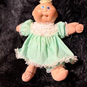 Boneca Cabbage Patch Kids vintage dos anos 80 - Careca com topete loiro, olhos azuis, vestido original verde menta pastel com detalhes em renda.