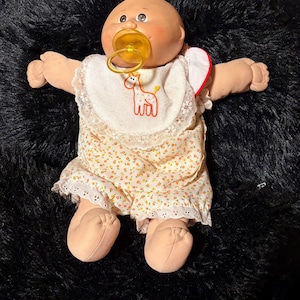 Bambola Cabbage Patch Kids vintage anni '80 - Calva con ciuffo biondo, occhi marroni, tutina floreale originale, bavaglino e ciuccio a forma di giraffa, Coleco