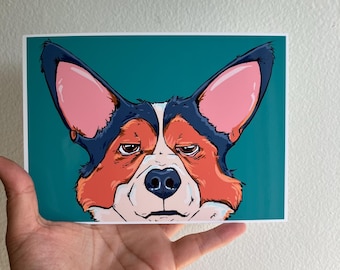 May include: A rectangular art print featuring a stylized illustration of a Corgi dog face. The dog has large pointed ears, a black, white, and orange coat, and a bored expression. The background is a solid teal color with a white border.