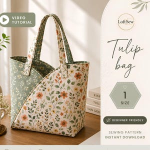 May include: A fabric tote bag with a curved top opening and two handles, featuring a floral pattern with orange and yellow flowers on a cream background, and a contrasting sage green interior lining with a white botanical print.