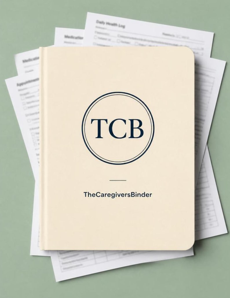 May include: A cream-colored binder with rounded corners featuring a dark blue circular logo containing the letters TCB. Below the logo, the text reads TheCaregiversBinder. The binder is placed on top of several white printed medical log forms.
