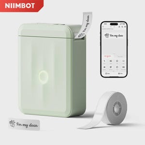 Puede incluir: Una impresora de etiquetas portátil de color verde claro con una tira de etiquetas blanca que sale por la parte superior, mostrando el texto "For my dear" con un icono de regalo. Un smartphone muestra la interfaz de la app y un rollo de etiquetas.