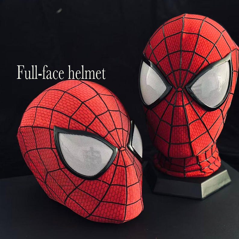 Puede incluir: Dos cascos integrales rojos con un patr&oacute;n de telara&ntilde;a negro y grandes lentes oculares de malla blanca. El texto "Full-face helmet" est&aacute; impreso en blanco a la izquierda. Un casco est&aacute; sobre un soporte y el otro descansa inclinado.
