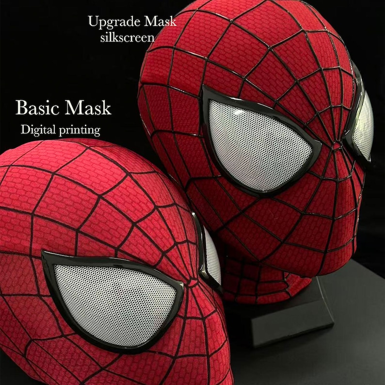 Puede incluir: Dos m&aacute;scaras de tela roja con patrones de telara&ntilde;a negros y lentes oculares de malla blanca. La m&aacute;scara superior est&aacute; etiquetada como Upgrade Mask silkscreen y la inferior como Basic Mask Digital printing. Ambas tienen dise&ntilde;o de cabeza completa.