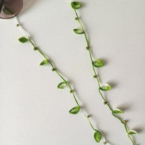 Könnte beinhalten: Eine weiße Keramik-Tasse mit schwarzem Henkel und dem Text "But First, Coffee" in fetter, schwarzer Schrift. Die Tasse steht vor einem verschwommenen Hintergrund. Die Tasse ist etwa 10 cm hoch.