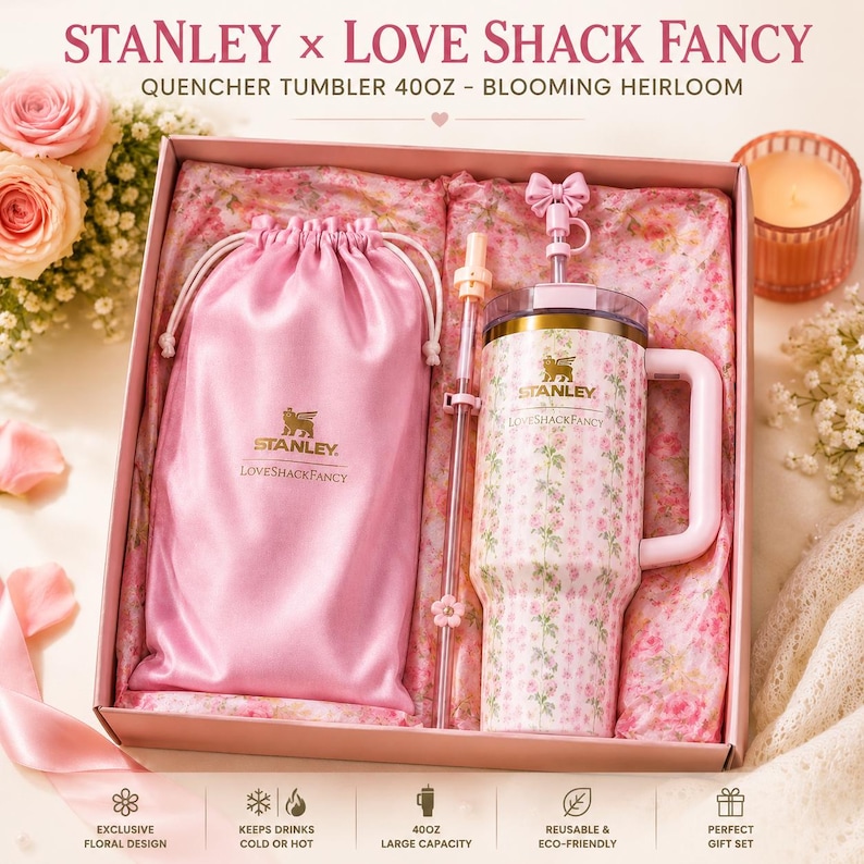 May include: A Stanley x Love Shack Fancy 40oz Quencher tumbler in a Blooming Heirloom floral print, featuring a pink satin drawstring pouch, a clear straw with a pink flower accent, and a pink bow straw topper, all presented in a gift box.