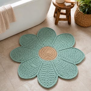 May include: A round, flower-shaped bath mat featuring a textured, crocheted design. The mat has eight large, light green petals surrounding a circular, tan-colored center. The construction shows a consistent, thick yarn stitch pattern throughout.