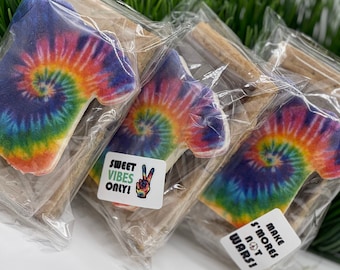 May include: Three individually packaged tie-dye cookies with a peace sign and the text "Sweet Vibes Only!" on one cookie and the text "Make S'mores Not Wars!" on another cookie.
