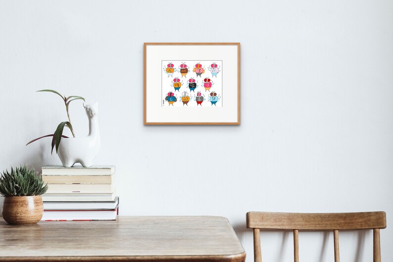 May include: A framed print of a colorful illustration featuring 12 cartoon characters with different expressions and outfits. Each character is a round, orange shape with a face and two small wings. The characters are arranged in a grid pattern.
